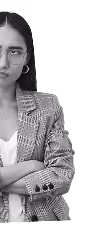 Black and white close-up of a serious young woman with glasses, wearing a plaid blazer and hoop earrings, arms crossed.